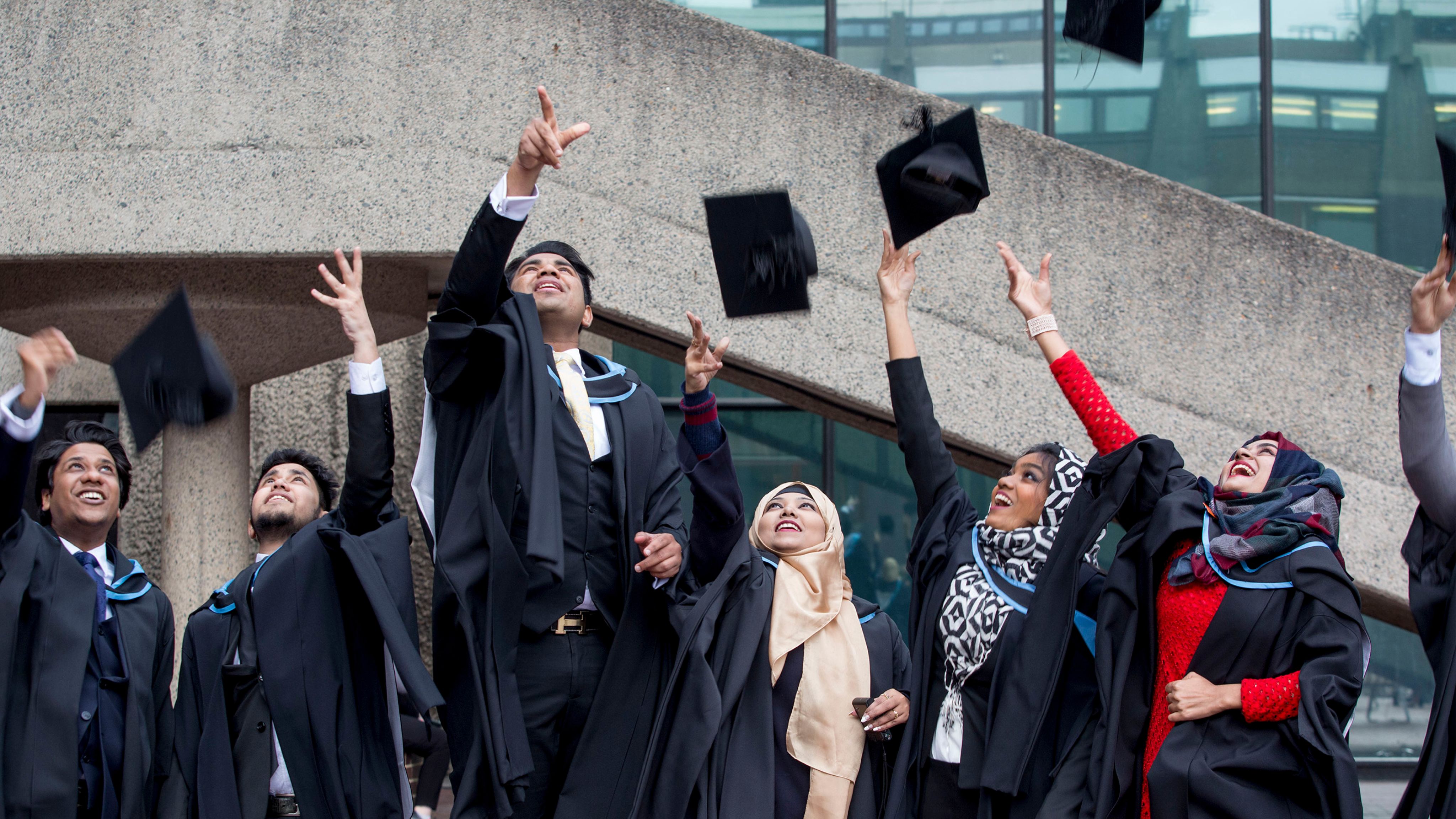 Graduates throwing mortar boards